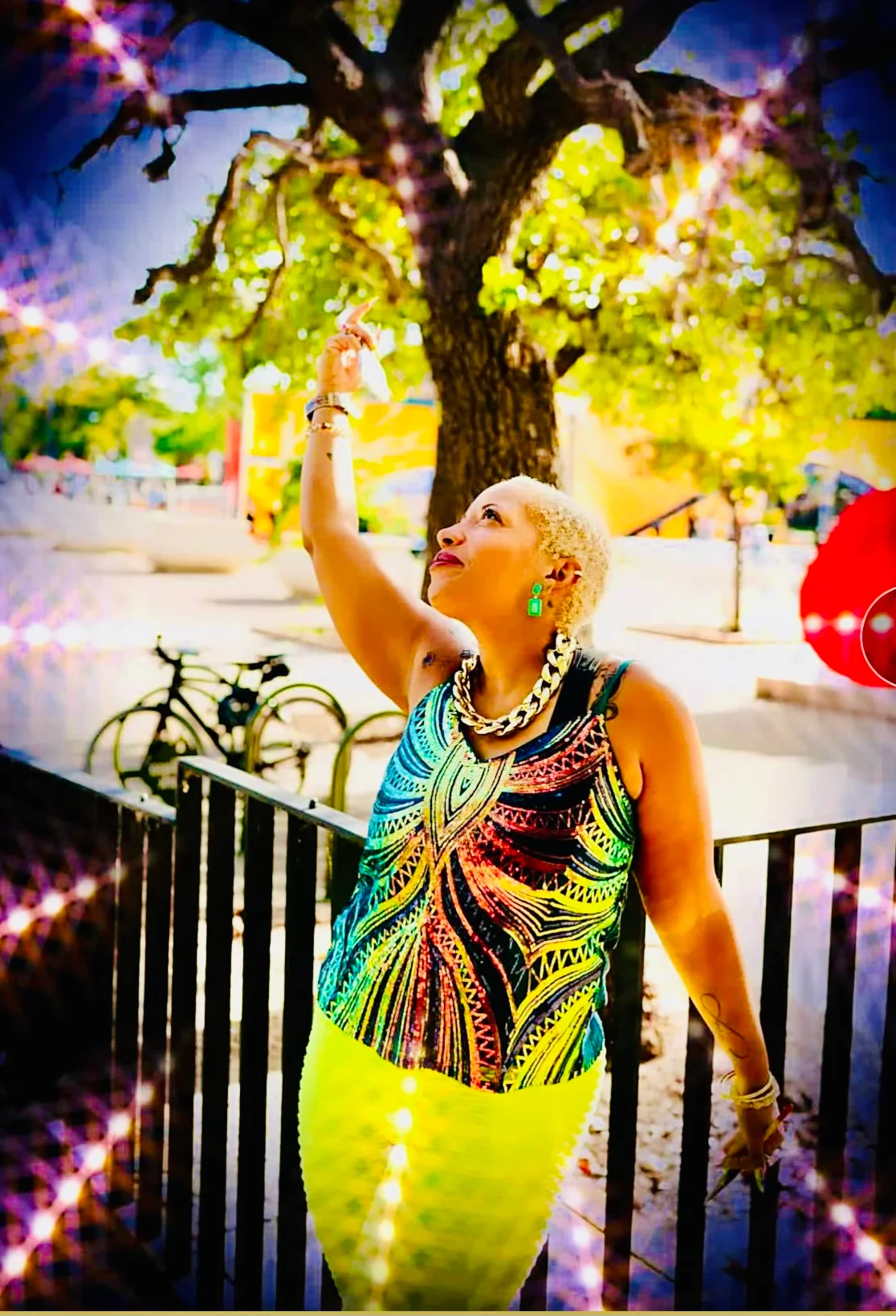 Jay Boyer outdoors in a colorful patterned top, pointing upward