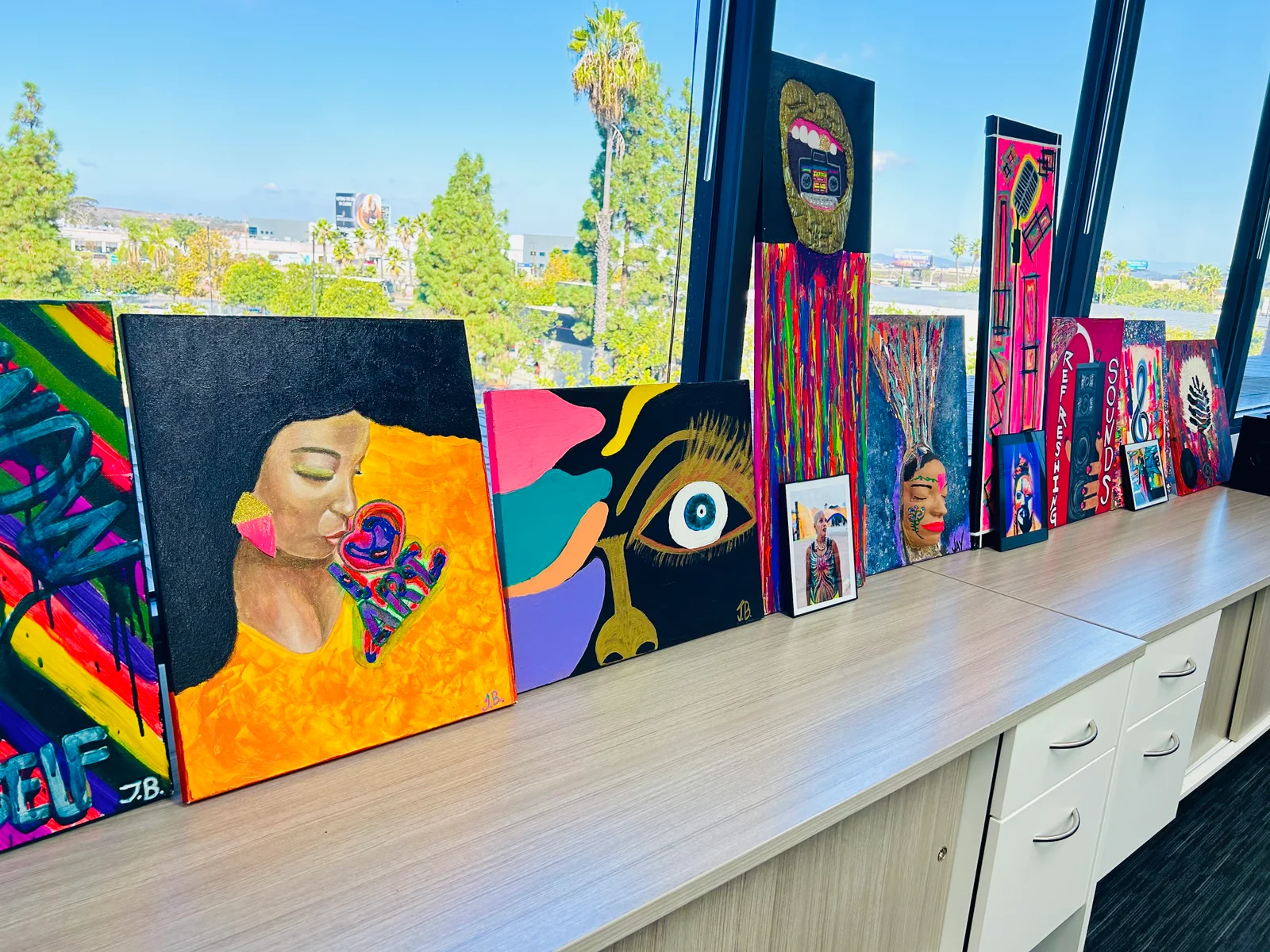 Finished paintings displayed along a window ledge